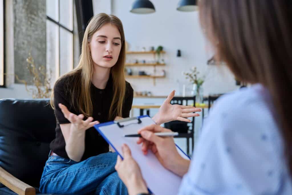 Young teenager girl talking to therapist about eating disorders in teenagers.