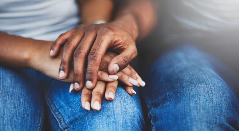 Supportive hands holding each other to symbolize care and compassion.